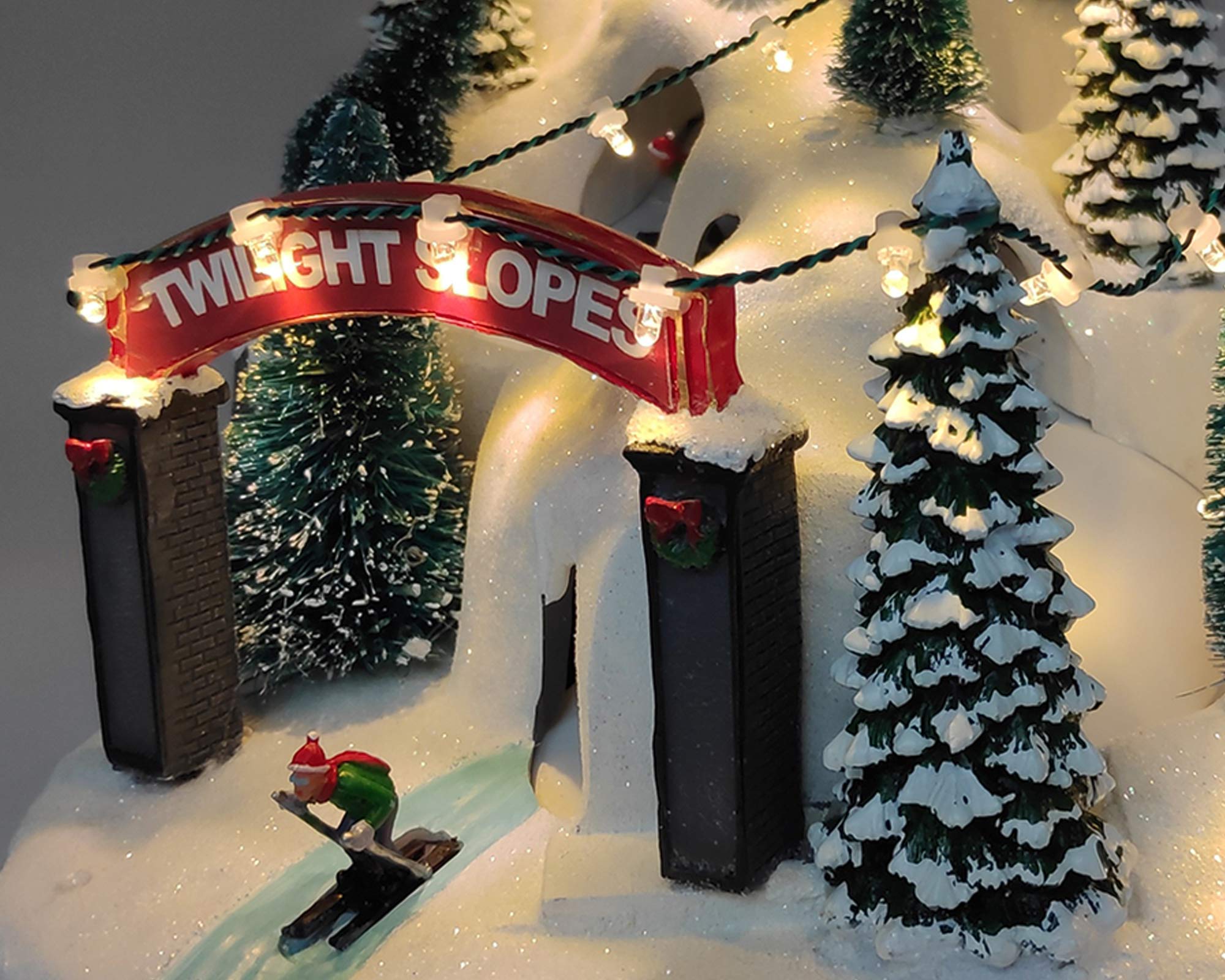 Villaggio natalizio innevato in movimento con sciatori - immagine 2