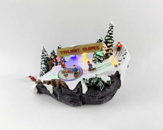 Villaggio natalizio innevato in movimento con sciatori