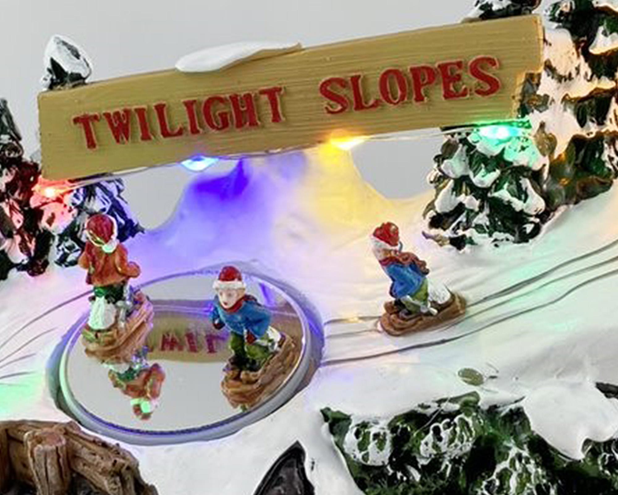 Villaggio natalizio innevato in movimento con sciatori - immagine 2