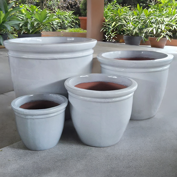 Vaso rotondo in ceramica smaltata nordic rim in varie grandezze all'esterno di un terrazzo.