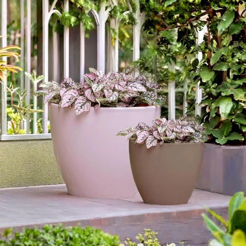 Vaso Decorativo Rotondo Duet Egg in Ceramica Smaltata rosa cipria e tortora all'esteno di un giardino