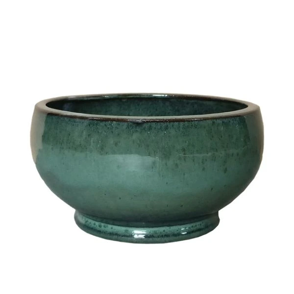 Vaso Decorativo Rotondo Noble Bowl Low in Ceramica Smaltata di Mega Collections (distribuita da Floral Garden). Questo elemento d'arredo basso e svasato (Bowl Shape) si sviluppa su una base solida con piedistallo pronunciato, ideale per dare vita a composizioni botaniche espanse o ospitare micro-paesaggi succulenti. Colore turchese spento su sfondo bianco.